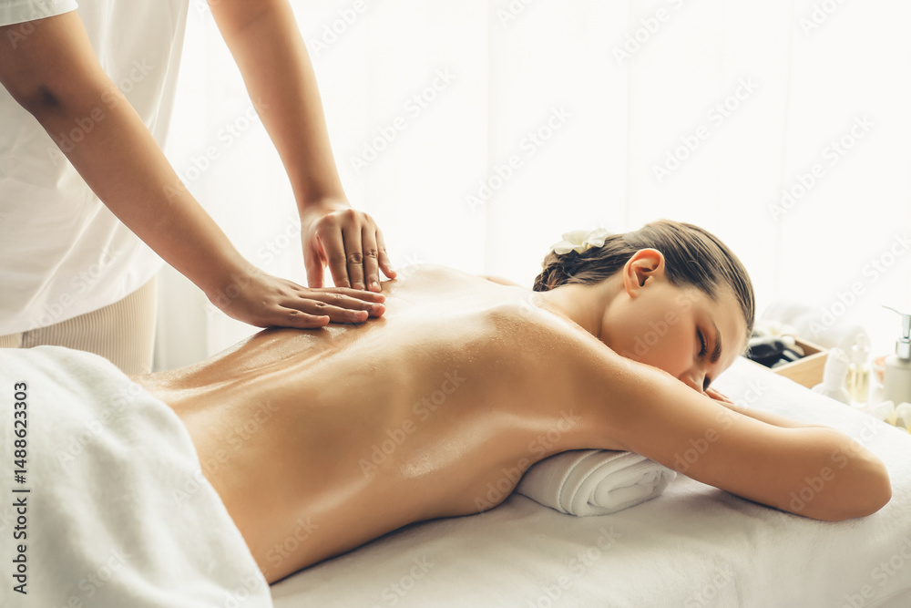 Fototapeta premium Caucasian woman customer enjoying relaxing anti-stress spa massage and pampering with beauty skin recreation leisure in day light ambient salon spa at luxury resort or hotel. Quiescent