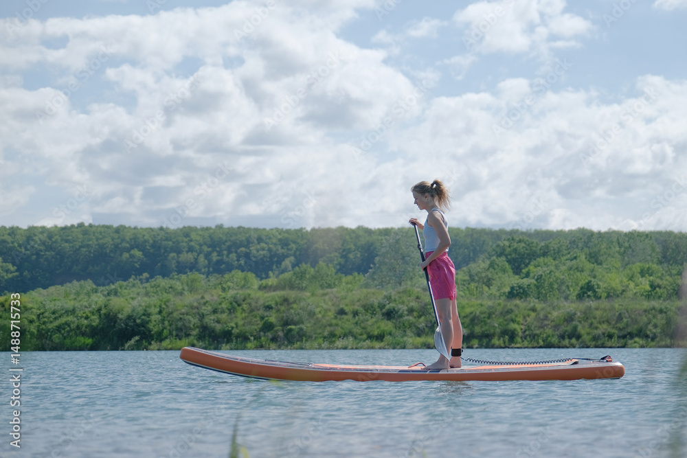 Naklejka premium happy woman rowing sup board on river water , paddleboard and surfing