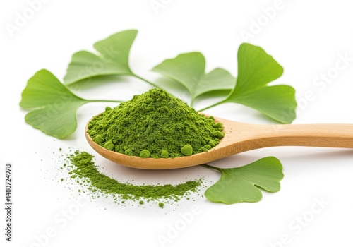 Ginkgo biloba powder on a wooden spoon with leaves isolated on a white background