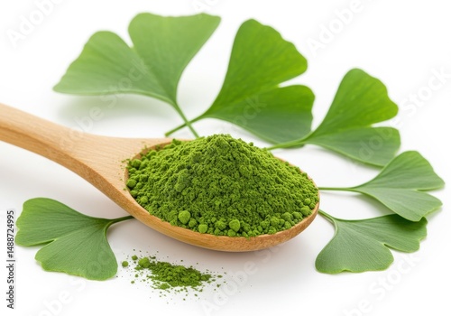 Ginkgo powder on a wooden spoon with ginkgo leaves isolated on a white background