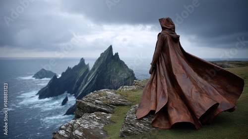 A bronze figure wearing a flowing cloak against a dramatic coastal landscape.