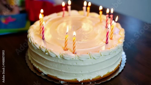 White frosted birthday cake displays many lit candles for celebration.