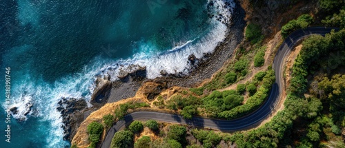 A winding coastal road hugs the shoreline, offering breathtaking views of the turquoise ocean and crashing waves.