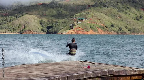 man kitesurfing from a dock in lake calima colombia
