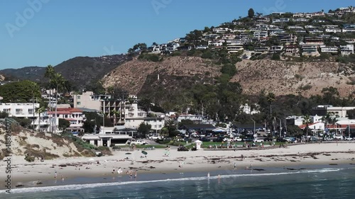 Aerial Panning Shot Of Tourists Enjoying Vacation At Beach In City On Sunny Day - Laguna Beach, California