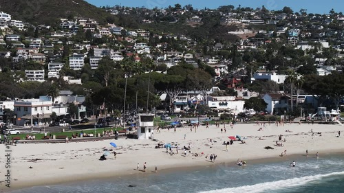 Aerial: Drone Panning Shot Of Male And Female Tourists At Beach On Sunny Day - Laguna Beach, California