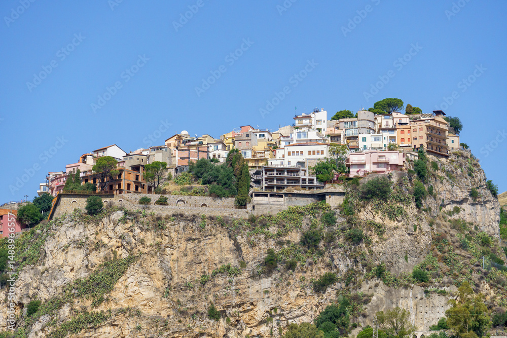 Obraz premium Beautiful view on the hilltop city of Castelmola, a typical sicilian village perched on a mountain, viewed from Taormina in Sicily, Italy 