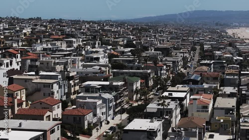 Aerial Panning Scenic Shot Of Buildings In City By Beach On Sunny Day - Manhattan Beach, California