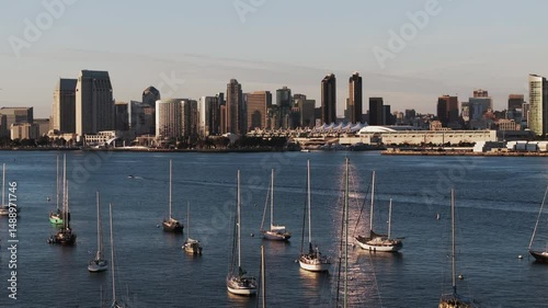 Aerial: Drone Forward Shot Of Nautical Vessels Floating On Rippled Sea By Modern City - San Diego, California