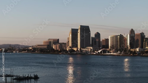 Aerial: Panning Scenic Shot Of Open-Air Music Venue By Modern Buildings In City, Drone Flying Forward Over Bay During Sunset - San Diego, California