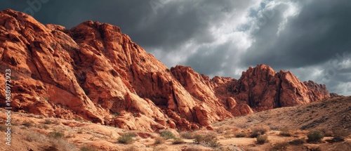 Dramatic red rock formations under a brooding sky. The rugged landscape evokes a sense of awe and wonder.
