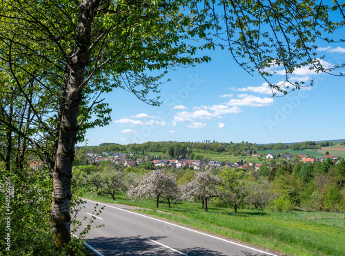 german countryside of saarland in spring with blossoming fruit trees and fresh colors under blue sky photo