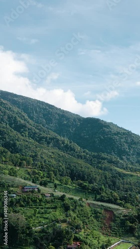 4K Vertical Drone Footage of Lush Mountain Landscape with Cloudy Sky

