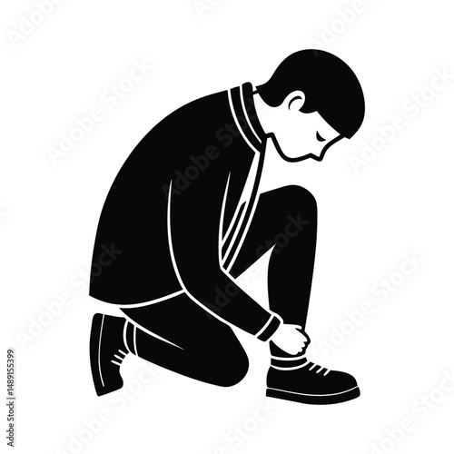 Man silhouetted kneeling tying shoelaces
