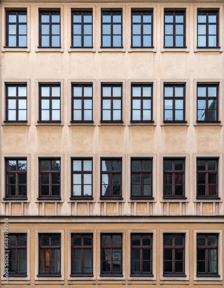 Fototapeta premium 縦に一直線に並ぶ正方形窓が映える伝統的古い住宅のシンメトリックなファサード