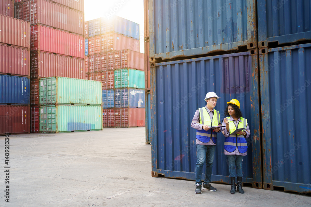 Fototapeta premium Businesswoman and logistic or shipyard engineer have a discussion or business due at container yard.