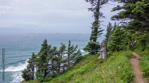Drone footage reveals Ecola State Park's dramatic coastline in Oregon, showcasing forest-covered cliffs, ocean waves, and pristine natural trails for hiking and sightseeing. photo