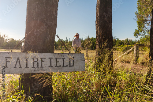 landowner standing in the driveway of his rural property, with sign in the foreground