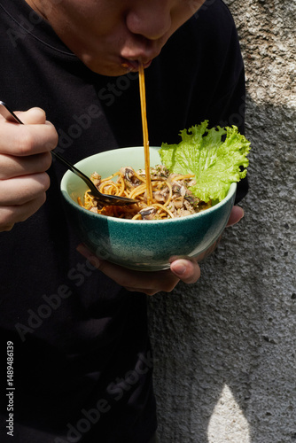 Eating a Bowl of Noodles Outdoors in a Relaxed Environment With Fresh Ingredients