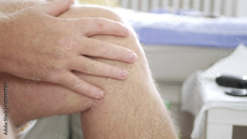 Tired Elderly Person Suffering from Rheumatism Pain Rubs His Feet Getting a Medical Massage.