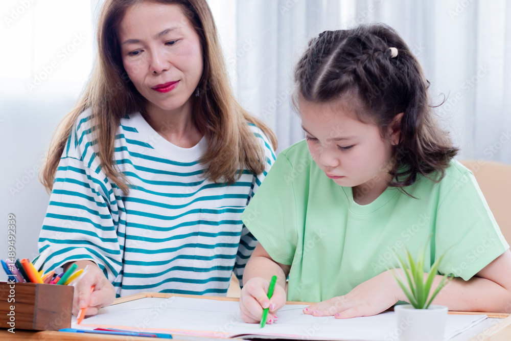 Asian mother and young daughter coloring, playing together bonding relationship family, mom multitasks and child share free time joyful drawing, teaching schoolwork with little girl, homeschool kid Asian mother and young daughter coloring, playing together bonding relationship family, mom multitasks and child share free time joyful drawing, teaching schoolwork with little girl, homeschool kid