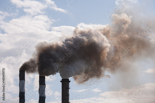 Smoke pouring from smokestacks at a rural sugar refinery