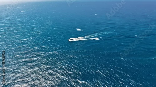 Aerial shot of sailing boat moving through the ocean photo