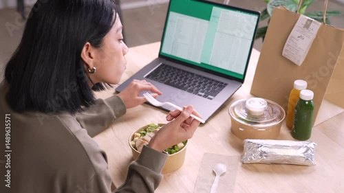 Woman eating healthy meal while working, Businesswoman having a lunch break at the office