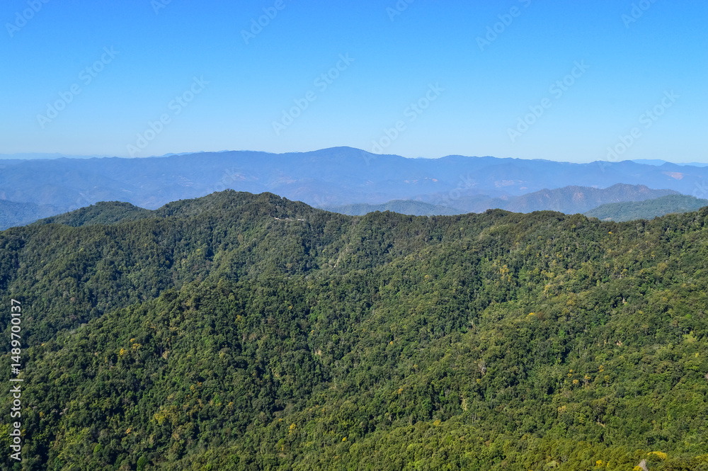 Obraz premium Distant Mountains and Forest with Trees and Sky in Northern Thailand.