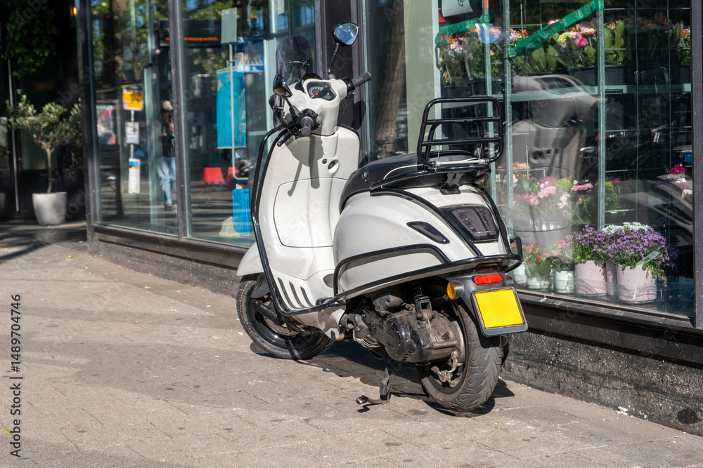 Scooter moto parked on road side, in front of a store. Netherlands Holland