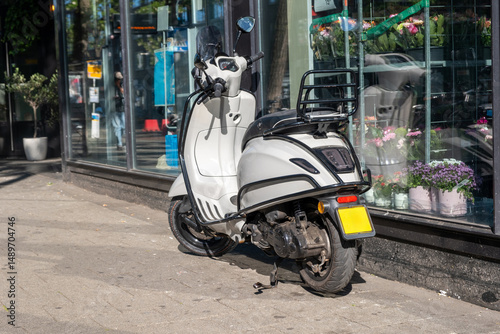 Scooter moto parked on road side, in front of a store. Netherlands Holland