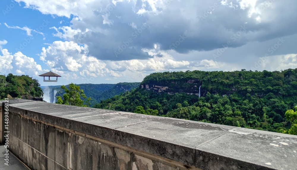 Fototapeta premium Rooftop View of Waterfall and Cliff Surrounded by Lush Forest Landscape