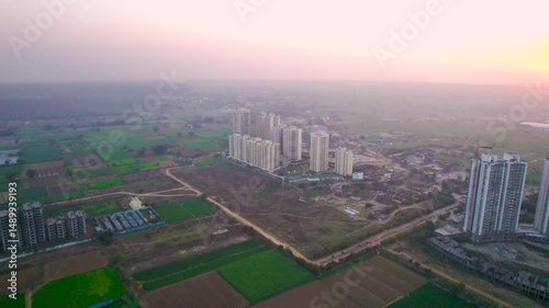 Wallpaper Mural Aerial drone shot flying towards under construction skyscrapers in the middle of farms green fields showing expansion of city and living in residences close to nature Torontodigital.ca