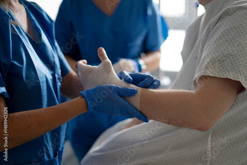 Wallpaper Mural Nurse bandaging patient's hand in hospital room Torontodigital.ca