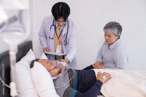 scene of a sad elderly woman holding hands a dying man on bed,on IV drip and oxygen,a doctor is physically examine,concept palliative care,end of life care