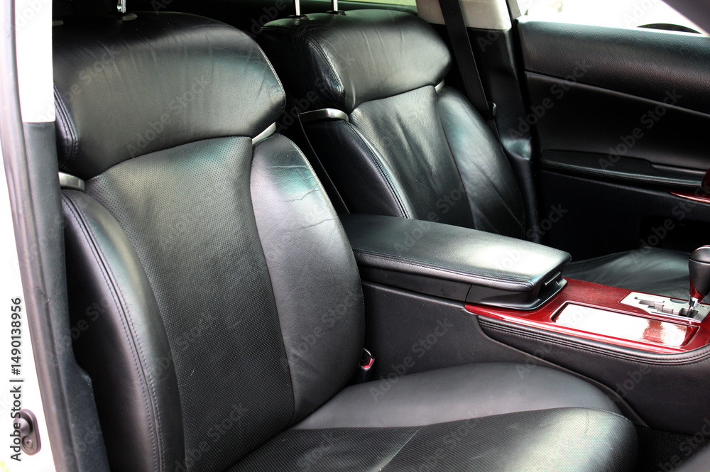 Fototapeta premium Premium car interior with light black high-tech comfortable seats and wooden trim. Lux car armrest with Automatic transmission lever shift. Automatic gearbox lever.