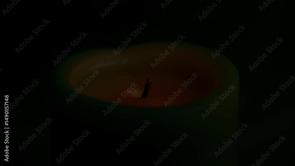 Candle glowing softly in dim light during nighttime  