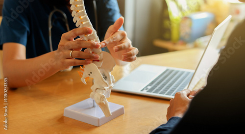 фотографія close up physical therapist hand pointing on human skeleton at back to advise an