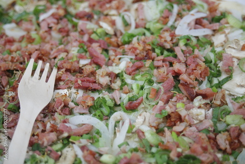 Elsässer Flammkuchen mit Gabel auf Teller in Nahaufnahme
