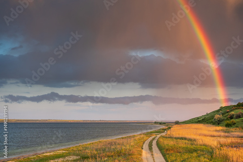landscape view to coast and rainbow with dramatic sky and copy space