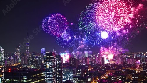Aerial view of colorful fireworks over a city skyline at night, festive atmosphere. Ideal for a celebratory video, 4th of July, New Year, Independence Day