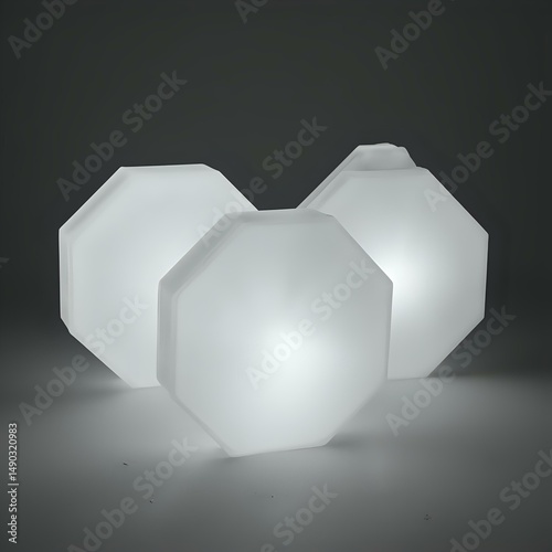 Three octagonal objects, each with a lighted interior, are arranged in a linear fashion against a dark backdrop, creating a stark, minimalist aesthetic.