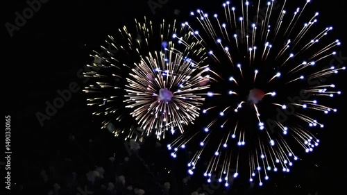 Vibrant display of colorful fireworks exploding in the night sky during a celebration, creating a spectacular view. Ideal for a celebratory video, 4th of July, New Year, Independence Day
