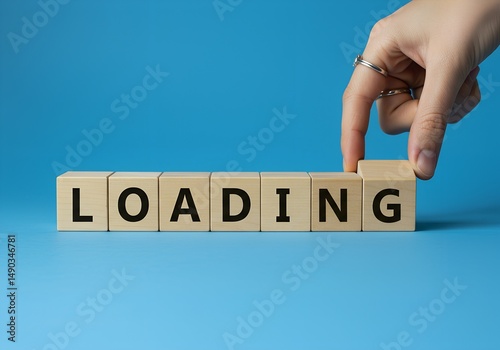 Finger places wood block to finish message reading LOADING against blue background