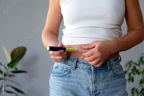 woman suffering from sugar diabetes giving insulin injection at home using diabetic pen