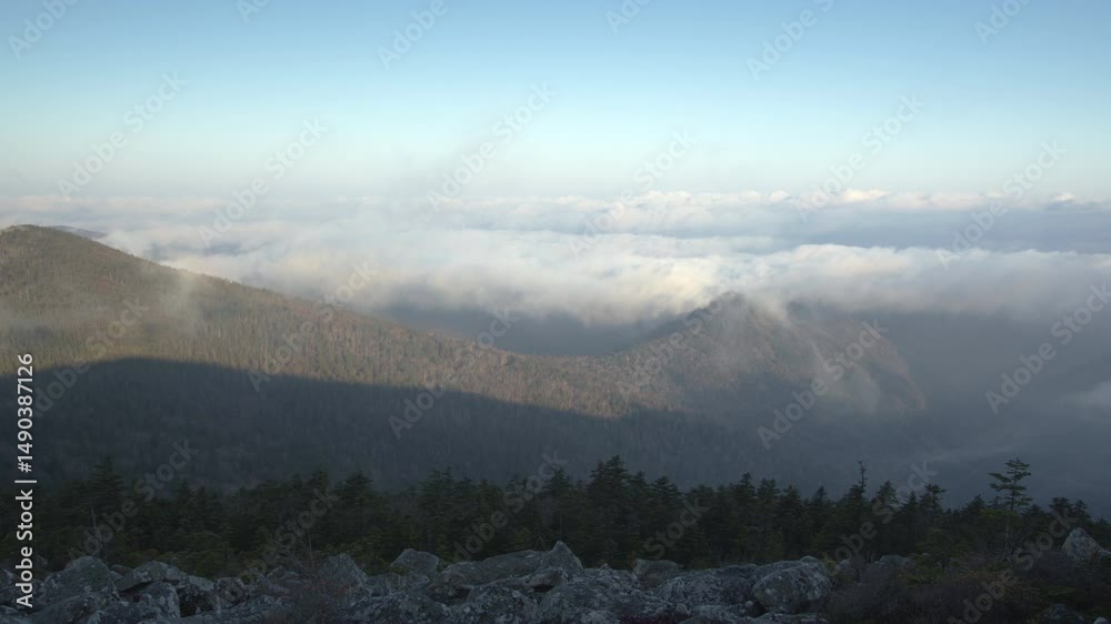 Fog envelops the mountains. Timelapse.