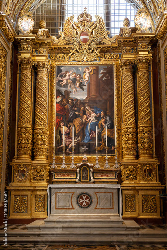 The interior of the St John's Co-cathedral in Valletta, Malta with opulent gold detailed ceilings and walls, and colourful marble floors.