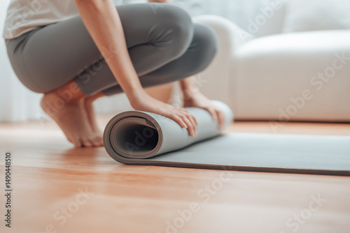 Fotografie Young Asian woman doing yoga, twisting on a mat in the living room at home