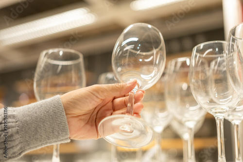 Woman customer selects ceramic tiles store market hall. Housewives buy dishes bowls and glass of water for the her house. Shopping kitchenware at warehouse store.