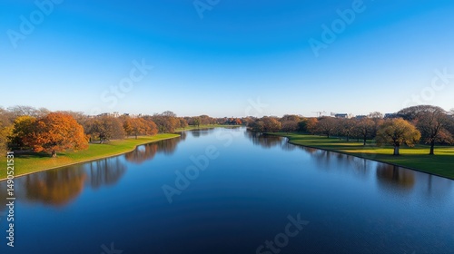 Scenic autumn waterway with reflective trees and clear sky